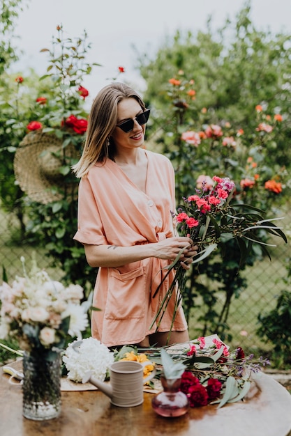 Donna che sistema i fiori in un giardino