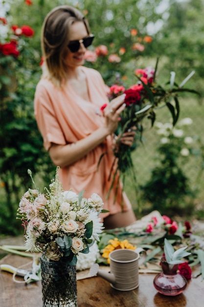 Donna che sistema i fiori in un giardino