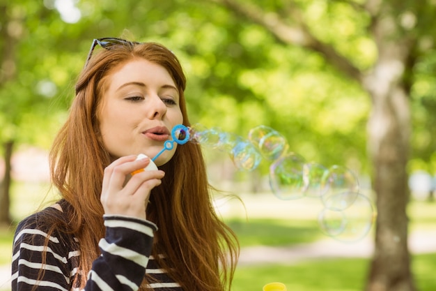 Donna che soffia bolle al parco