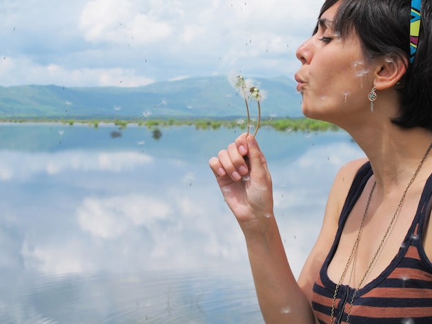 Donna che soffia un dente di leone