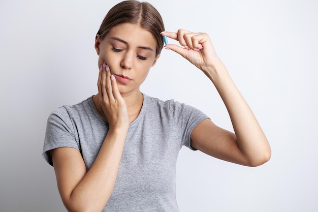 Donna che soffre di dolore ai denti e tocca la guancia