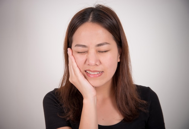 Donna che soffre di mal di denti con la mano sul viso