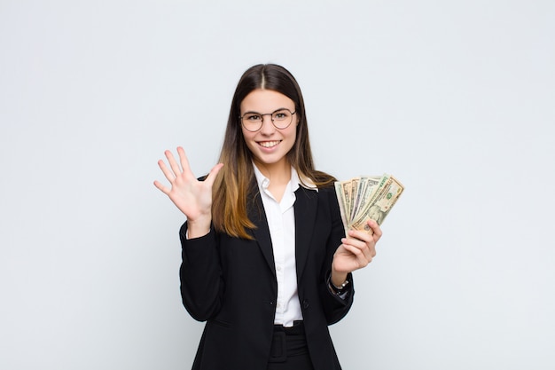 Donna che sorride e che sembra amichevole, mostrando numero cinque o quinto con la mano in avanti, conto alla rovescia