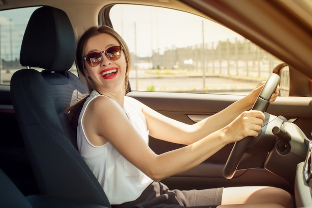 Donna che sorride mentre guidando un'automobile