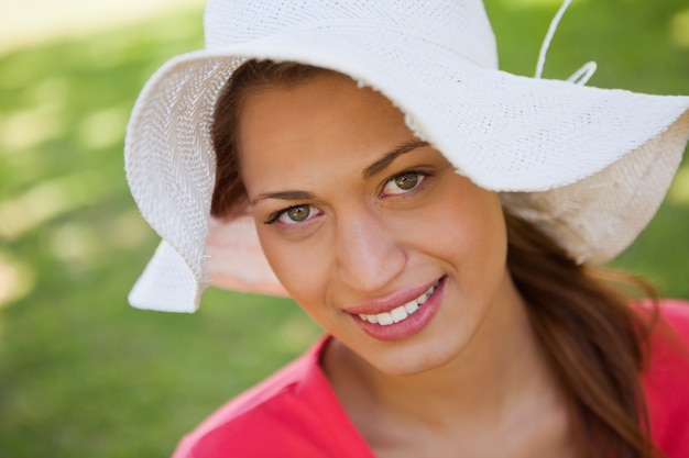 Donna che sorride mentre indossa un cappello bianco