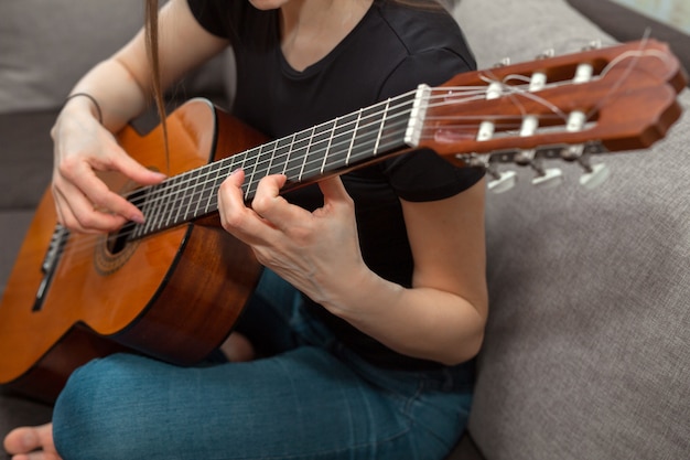 donna che suona la chitarra a casa