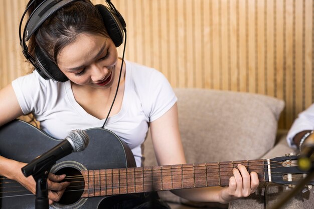 Donna che suona la chitarra in una stazione radio