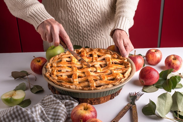 Donna che taglia una mela al forno con un khife dessert tradizionale del Ringraziamento pronto da mangiare con mele rosse e verdi preparazione della torta del Ringraziamento panetteria autunnale dolci del clima croccante Ricetta