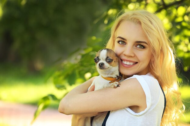 Donna che tiene cane birichino nel parco