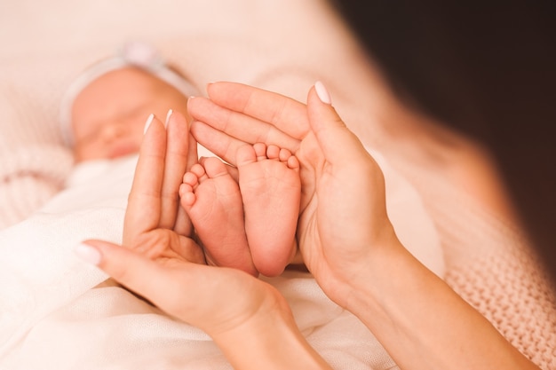 Donna che tiene i piedi del bambino nel letto primo piano