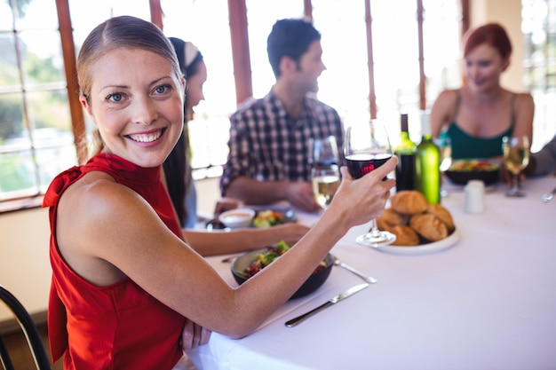 Donna che tiene il bicchiere di vino in ristorante