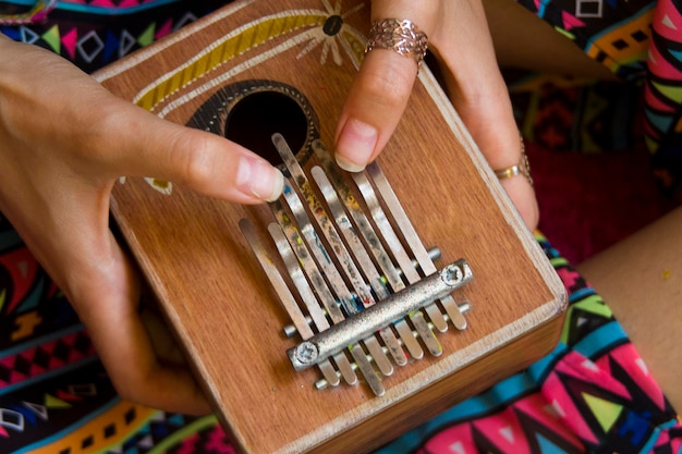 Donna che tiene il kalimba nelle sue mani e suona lo strumento etnico africano Europa versione kalimba
