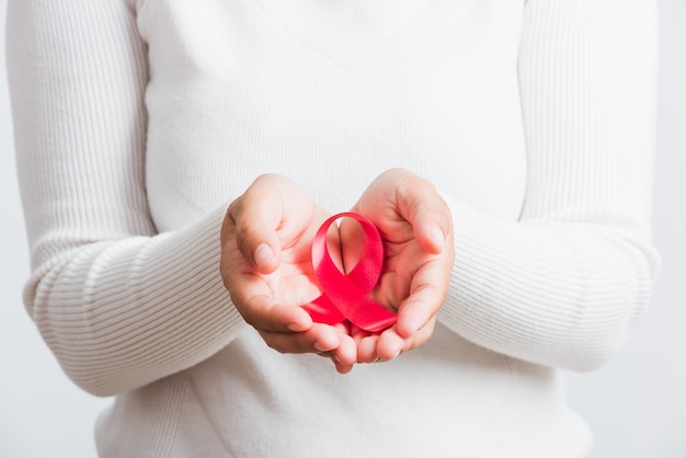 donna che tiene il nastro rosa di consapevolezza del cancro al seno sulle mani