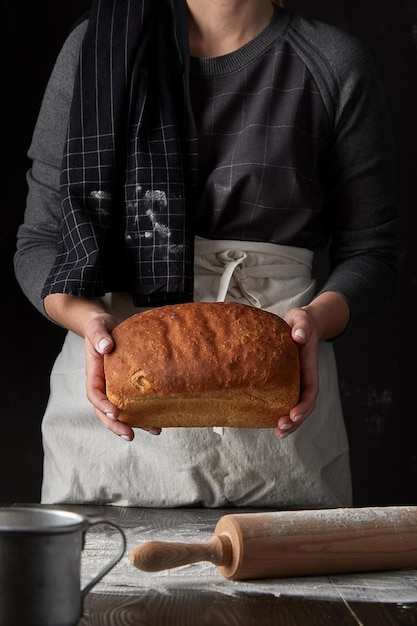 Donna che tiene il pane fresco fatto in casa nelle sue mani