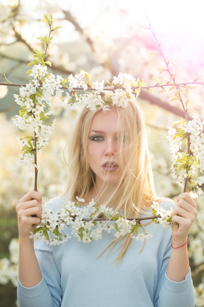 Donna che tiene in mano una cornice di fiori bianchi che sbocciano