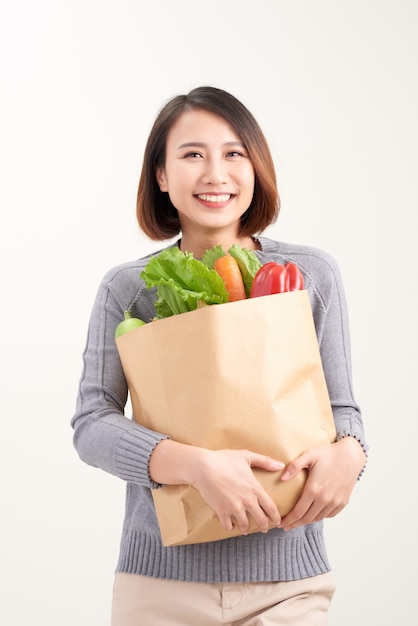 Donna che tiene la borsa della spesa su sfondo bianco