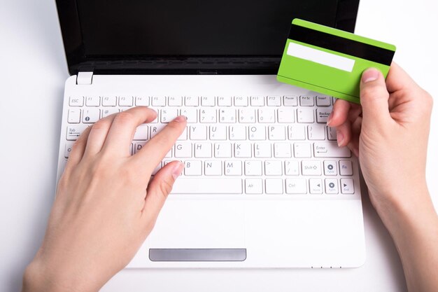 Donna che tiene la carta di credito e utilizza il laptop per lo shopping online