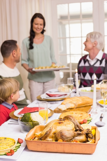 Donna che tiene la cena di Natale con la famiglia al tavolo da pranzo