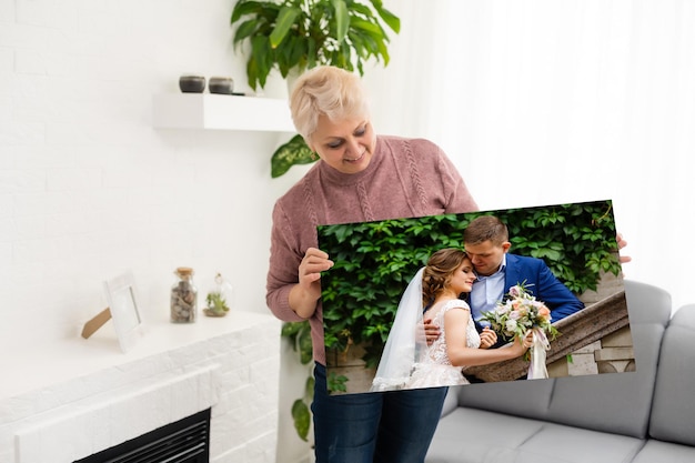 Donna che tiene la fotografia di matrimonio stampa su tela con galleria avvolgente.