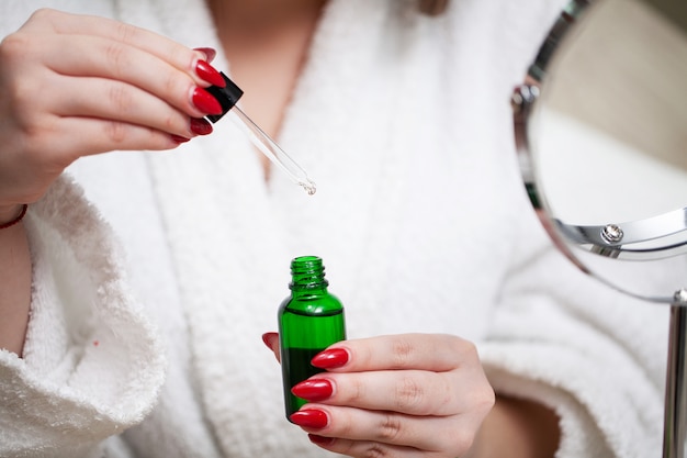 Donna che tiene nella sua crema mani per la cura della pelle del viso