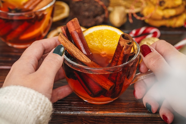 Donna che tiene tazza con vin brulé in sue mani