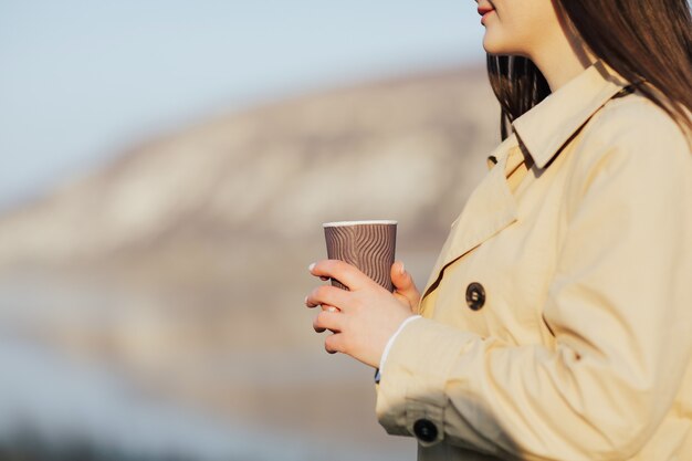 donna che tiene tazza di caffè usa e getta