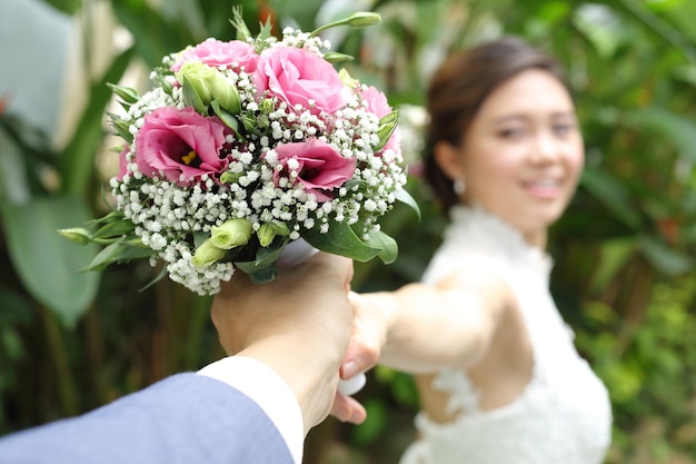 Donna che tiene un bouquet colorato con le mani nel giorno del matrimonio