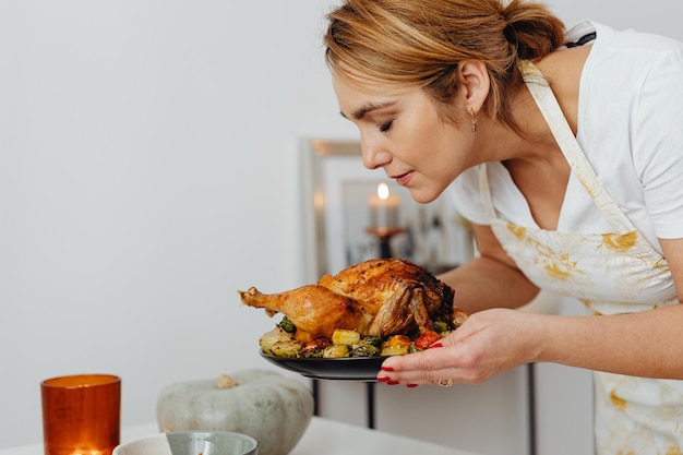 donna che tiene un vassoio con tacchino arrosto il giorno del ringraziamento