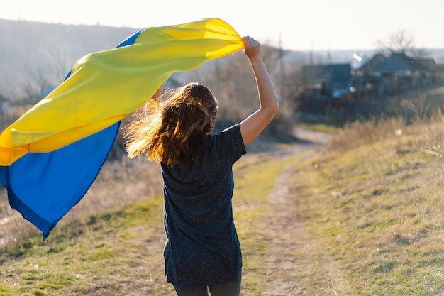 Donna che tiene una bandiera gialla e blu dell'ucraina all'aperto