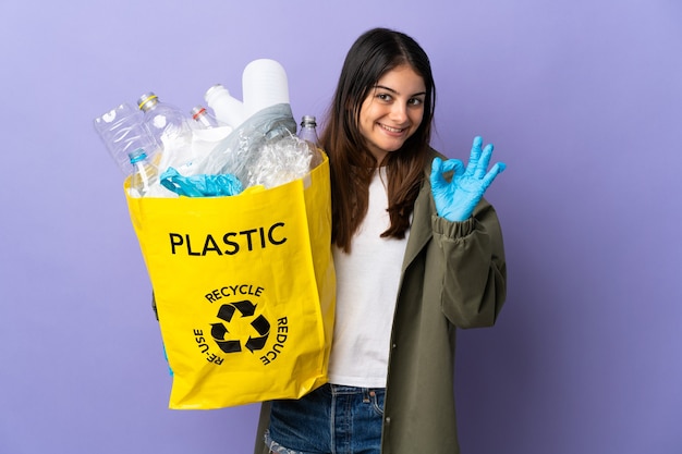 Donna che tiene una borsa piena di bottiglie di plastica da riciclare