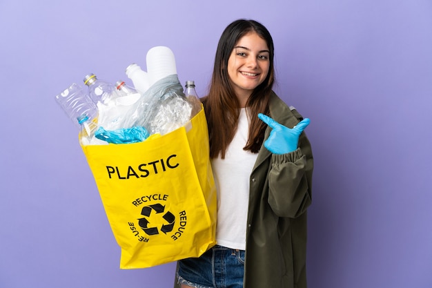 Donna che tiene una borsa piena di bottiglie di plastica da riciclare