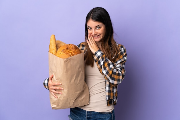 Donna che tiene una borsa piena di pane