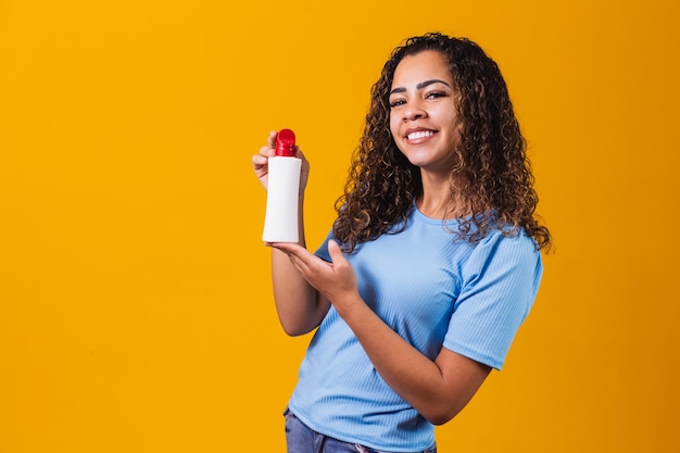 Donna che tiene una crema su sfondo giallo