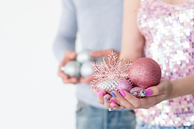 donna che tiene una manciata di palline scintillanti oro rosa e fiocco di neve