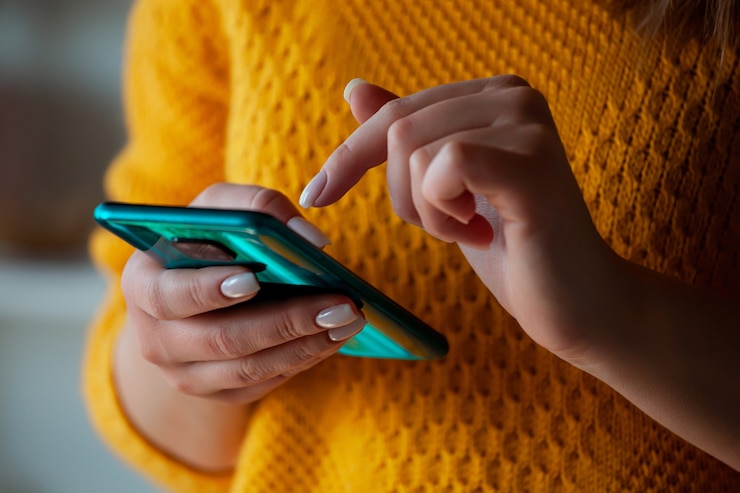 Foto donna che usa il cellulare, tenendosi per mano