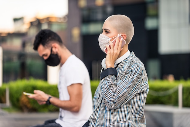 Donna che usa il suo cellulare durante la pandemia covid-19, concetti di distanza sociale, tecnologia e virus corona.