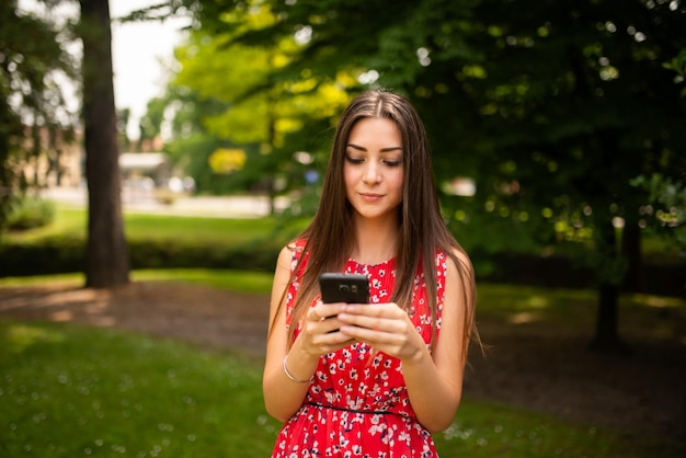 Donna che usa il suo cellulare in un parco