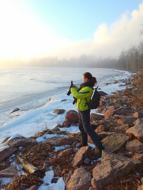 Donna che usa il telefono vicino al lago