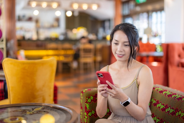 Donna che usa lo smartphone in un caffè.