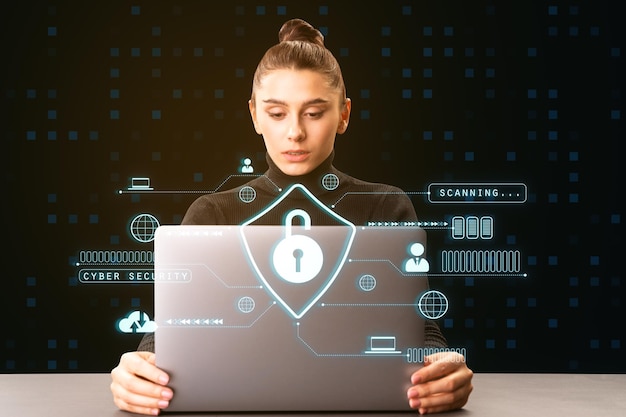 Donna che usa un portatile con ologrammi di sicurezza informatica su uno sfondo digitale scuro