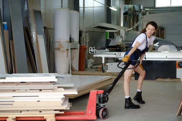 Donna che utilizza carrello idraulico nel laboratorio di falegnameria