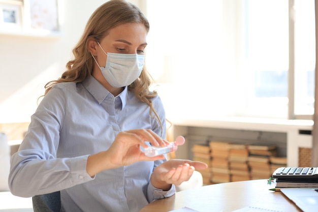 Donna che utilizza gel disinfettante per le mani. Protezione da coronavirus per l'igiene delle mani.