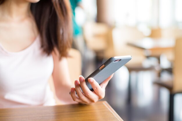 Donna che utilizza il cellulare all'interno del caffè