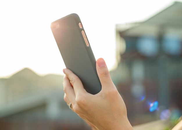 Donna che utilizza il cellulare sotto la luce del sole