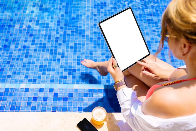 Donna che utilizza il computer tablet dal mockup dello schermo verticale della piscina
