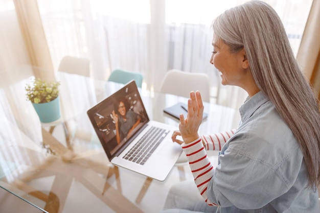 Donna che utilizza il notebook per la comunicazione online a casa