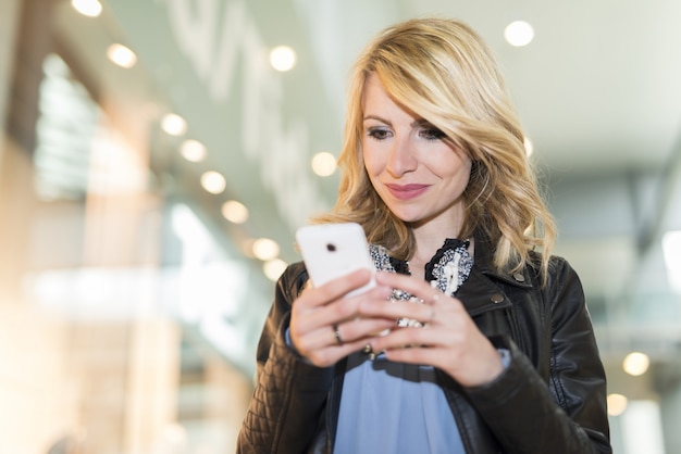 Donna che utilizza il suo telefono cellulare in un centro commerciale