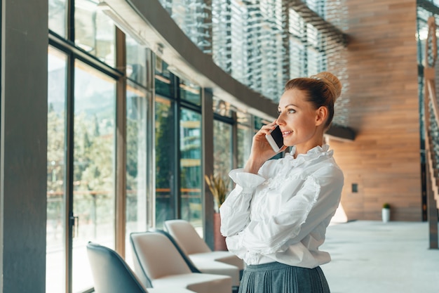 Donna che utilizza il telefono cellulare in ufficio