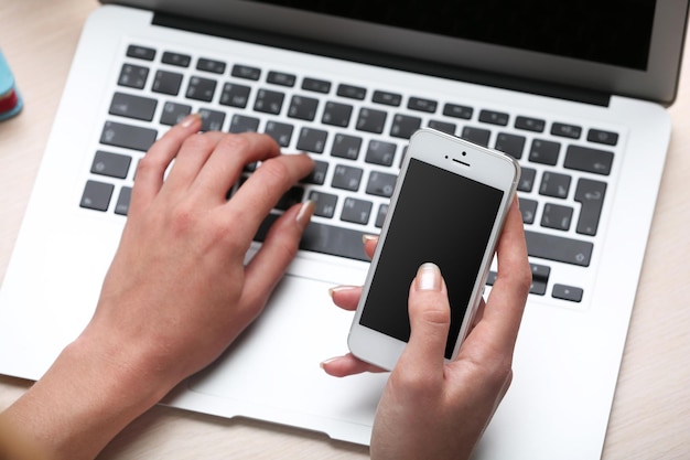 Donna che utilizza il telefono cellulare sul posto di lavoro da vicino