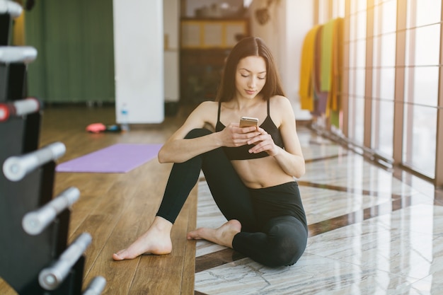 Donna che utilizza il telefono durante l&#39;allenamento